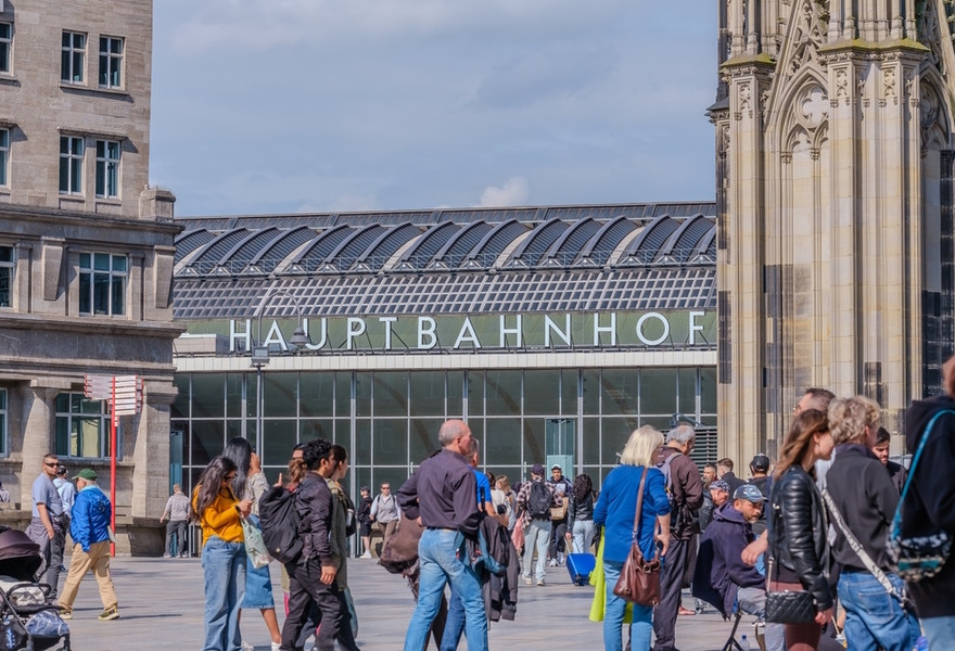 A busy train station in Cologne, Germany, showcasing the increased rail travel due to the affordable 49-euro public transport ticket.