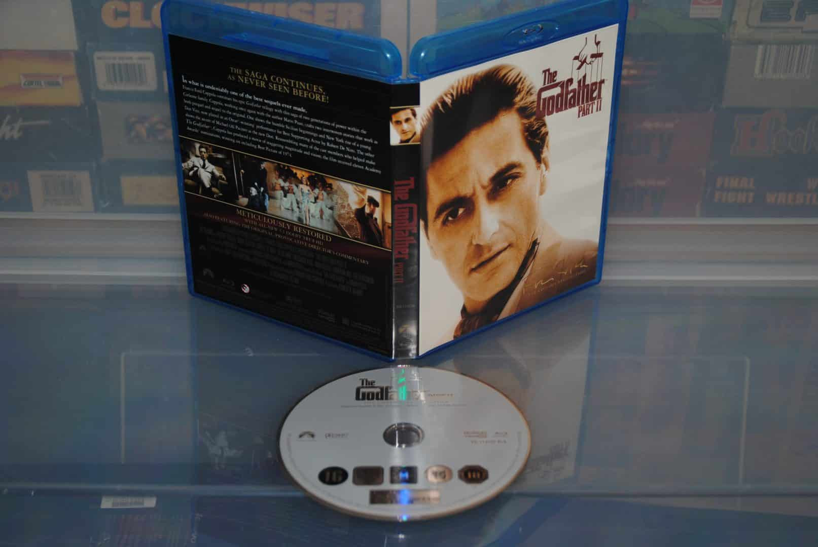 The three Godfather Blu-ray movie cases included in the Blackhand Edition PS3 set, featuring Godfather 1, 2, and 3, displayed as part of a collector's edition package that enhances the value proposition for movie and game enthusiasts.